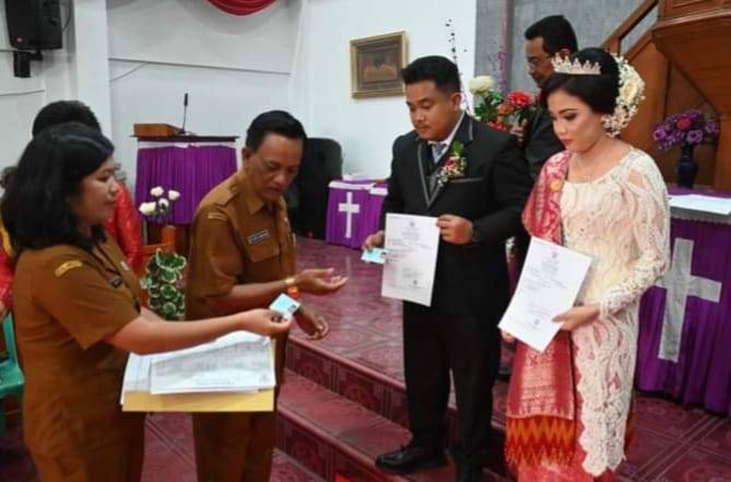 Kadis Dukcapil Humbahas Serahkan Dokumen Kependudukan Kepada Pasangan Pengantin Baru
