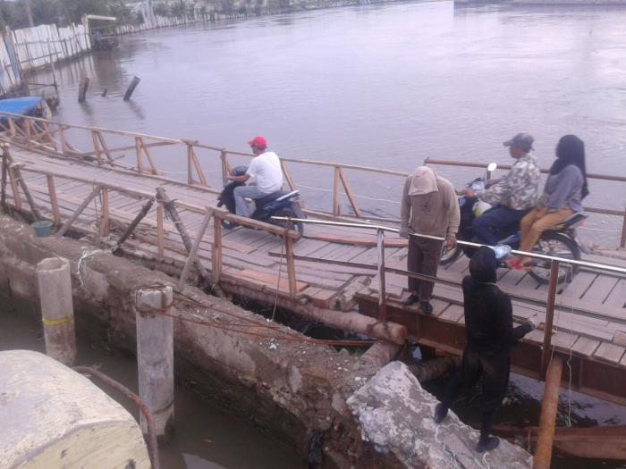 Warga Sicanang Gunakan Jembatan Sementara