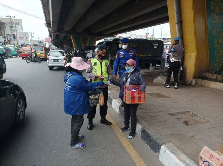 Tekan Covid-19, Brimob Poldasu Sampaikan Imbauan Prokes dan Bagikan Masker ke Masyarakat